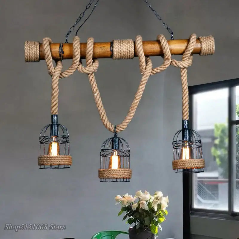 Rustic industrial pendant light with natural bamboo bar and beige bamboo hemp rope suspending black metal cage lamps