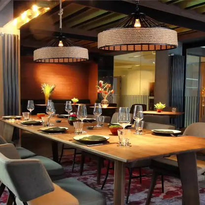 Rustic industrial pendant light with rattan-woven hemp rope and black metal frame installation above dining table