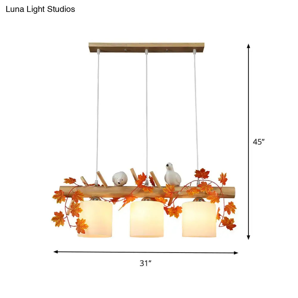 Rustic wooden pendant light with ivory glass shades featuring maple green leaf and bird décor for kitchen islands