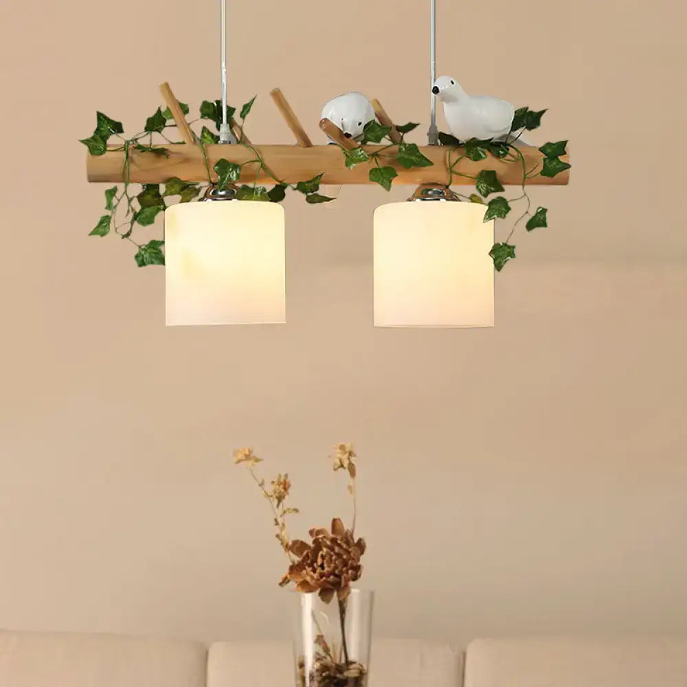 Rustic wooden pendant light with ivory glass shades featuring maple green leaf and white ceramic bird decor