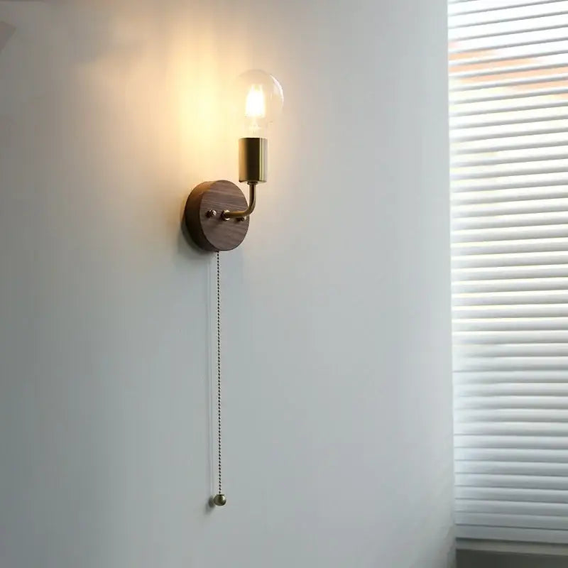 Rustic led walnut wood wall sconce with warm brass and round wooden backplate featuring an exposed filament bulb