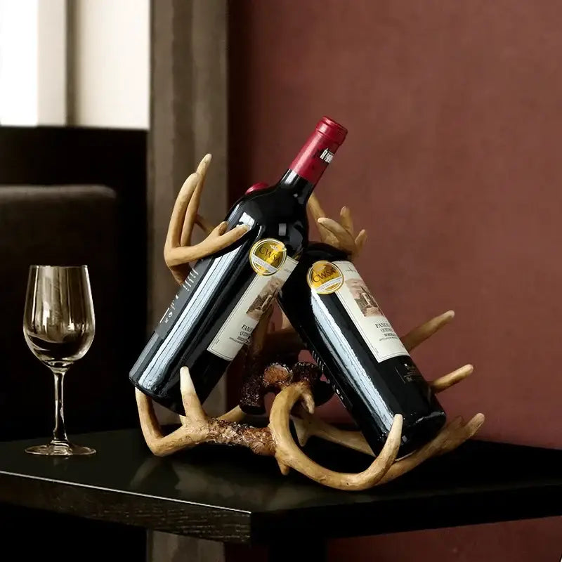 Rustic natural resin buckhorn wine holder with antler design holding two dark bottles with red foil caps decorbites wine holder