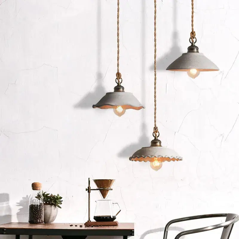 Rustic off white ceramic pendant light trio with twisted rope cords and scalloped matte gray shades for cement loft style decorbites