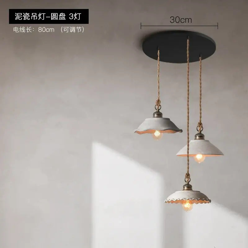 Rustic off white ceramic pendant light trio with scalloped edges hanging from twisted rope cords for cement loft style decor