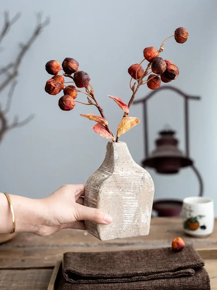 Beige speckled ceramic hydroponic vase with textured handcrafted surface holding dried autumn berries for decorbites garden rattan