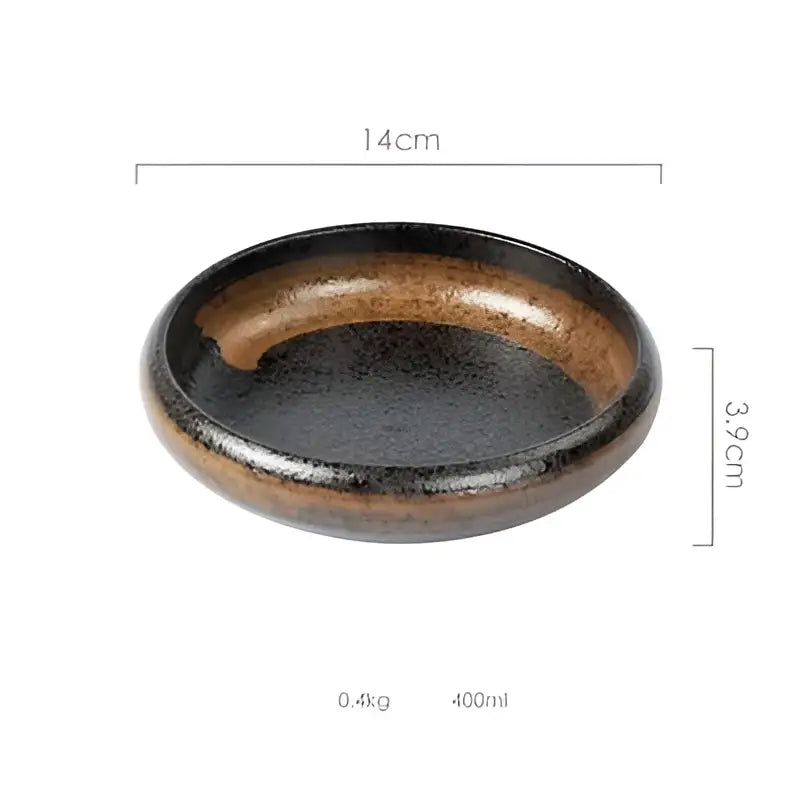 A sleek oval ceramic kimchi plate with glossy black glaze and earthy brown speckles along the rim