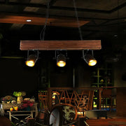 DecorBites vintage 3-headed metal pendant light with black barrel shades on a rustic linear wooden beam