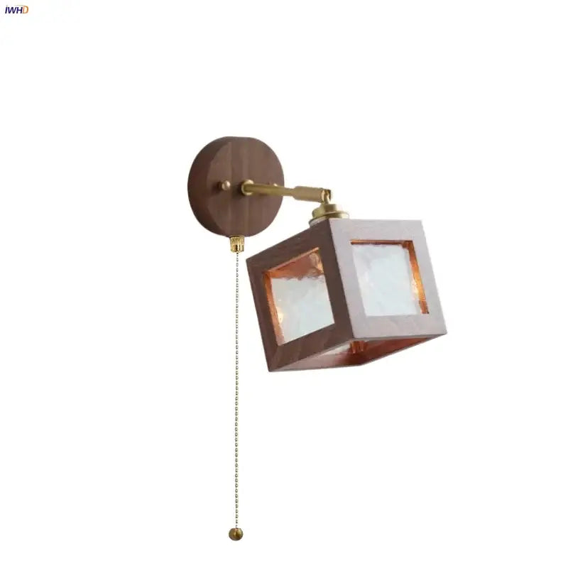 Rustic walnut and brass wall light fixture with a dark wood base and glass light for bedroom use