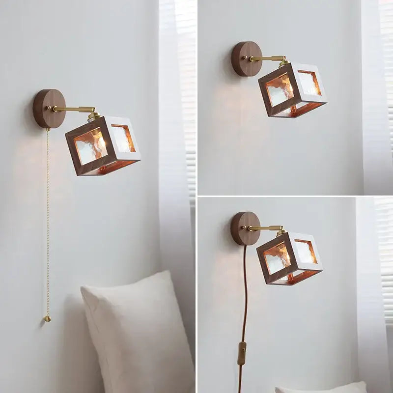 A modern wall light fixture with a square walnut frame, brass accents, and copper interior panels for bedroom use