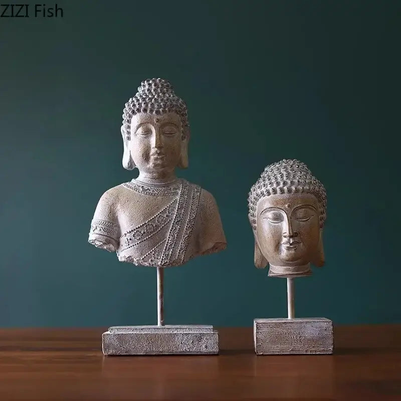 Two rustic weathered bronze buddha head statues in gray resin on slender metal stands for living room decor