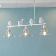 White bird-themed island light fixture with three clear glass shades and sculpted birds on a horizontal bar for balcony