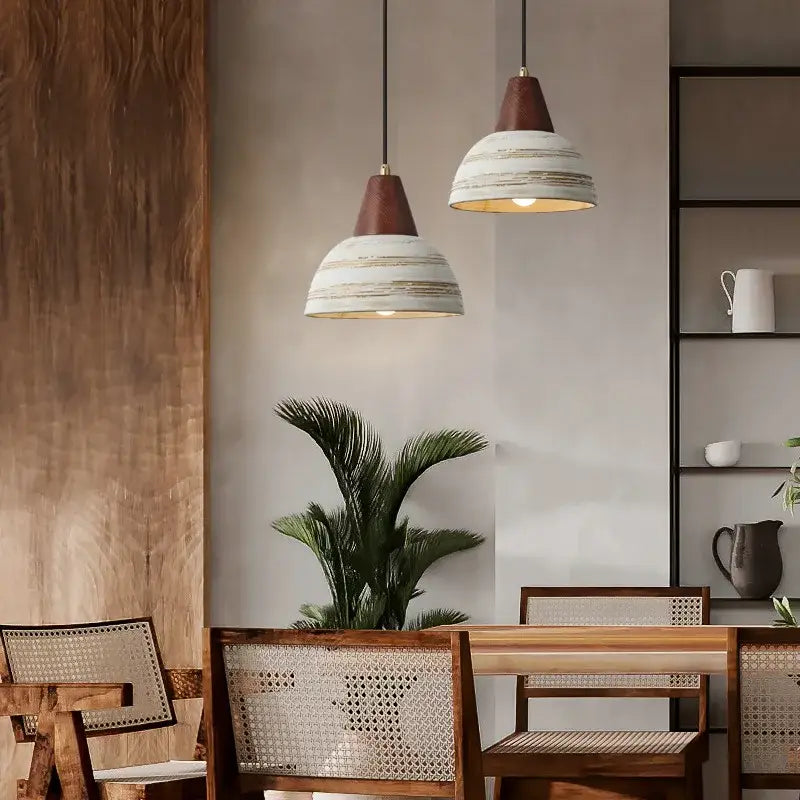 Two rustic white and wood ceramic pendant lights with distressed shades hang from black cords for kitchen decorbites ceramic wood led lighting