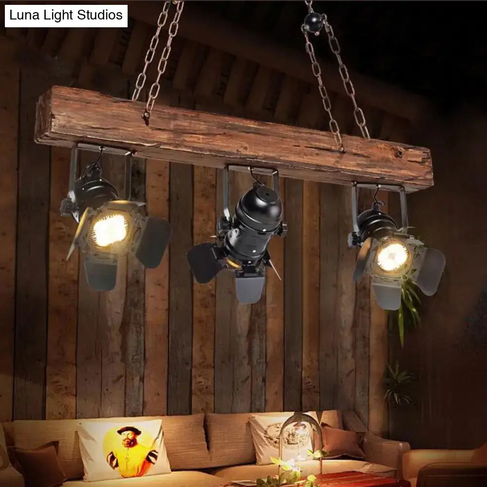 Rustic wood and black metal 3 light island pendant kitchen light with wooden beam and three black industrial spotlights hanging from chains
