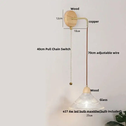 Rustic wood and brass wall light with pull chain switch featuring a natural wood base, copper arm, and clear glass shade