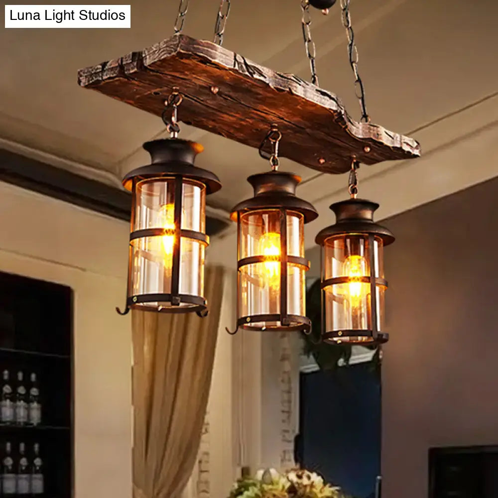 DecorBites™ clear glass island pendant light with three rustic wooden lantern-style fixtures and dark metal frames