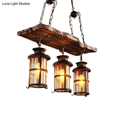 Rustic wooden plank pendant light with three brass lanterns and clear glass panels for clear glass island use