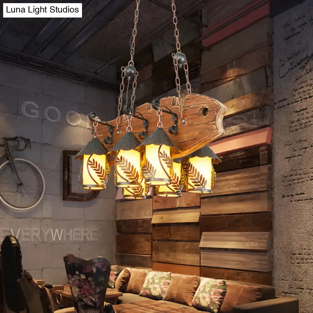 Rustic wood and glass dining room chandelier with five amber lanterns leaf cutouts and black metal arm island lamp