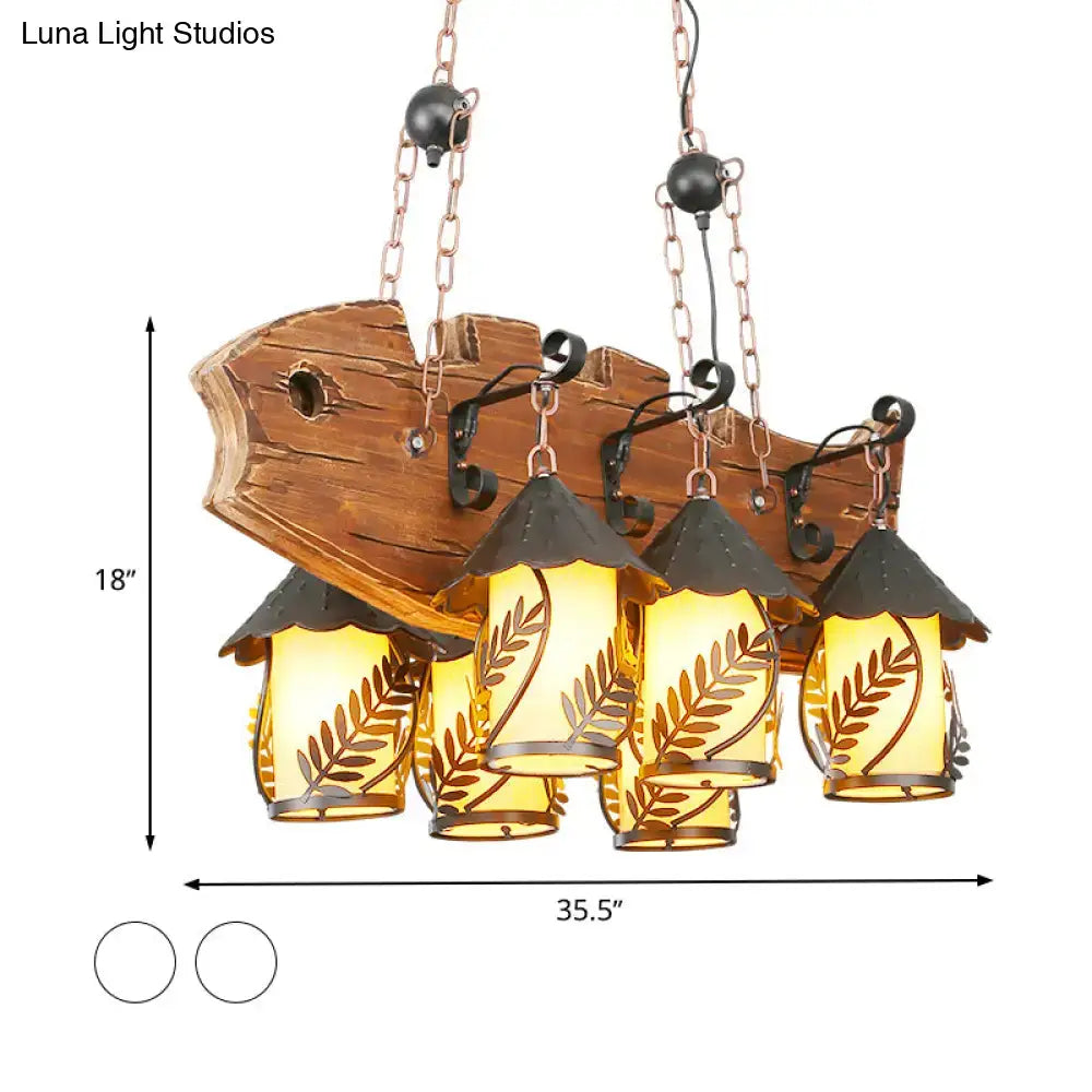 Rustic wood and glass dining room chandelier with amber lanterns, leaf cutouts, and black metal arm island lamp