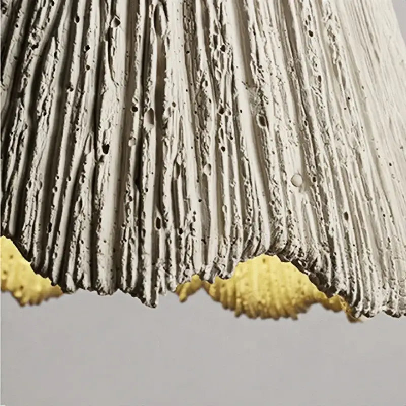Rustic wood and gray wall light fixture with textured white concrete lampshade and scalloped golden yellow trim