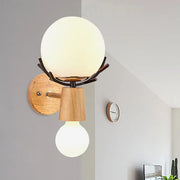 Rustic wall lamp featuring a white globe sconce with frosted glass on dark metal branches and wooden base for stairways
