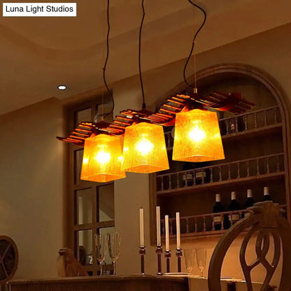DecorBites rustic wood island lamp with warm yellow crackle glass shades hanging over a dining room island