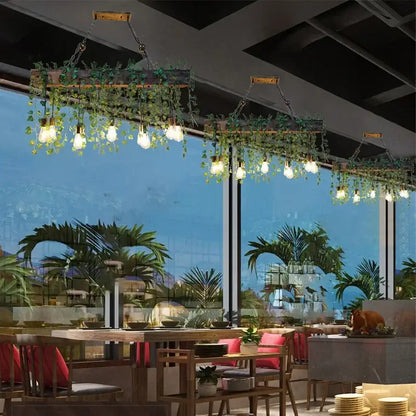 Rustic wood hanging chandeliers with green vines and edison bulbs designed as bar hanging chandeliers for dining rooms