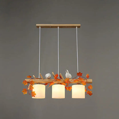 Decorbites modern wood linear island lighting with warm-toned shades, natural wood frame, and maple leaf plant accents