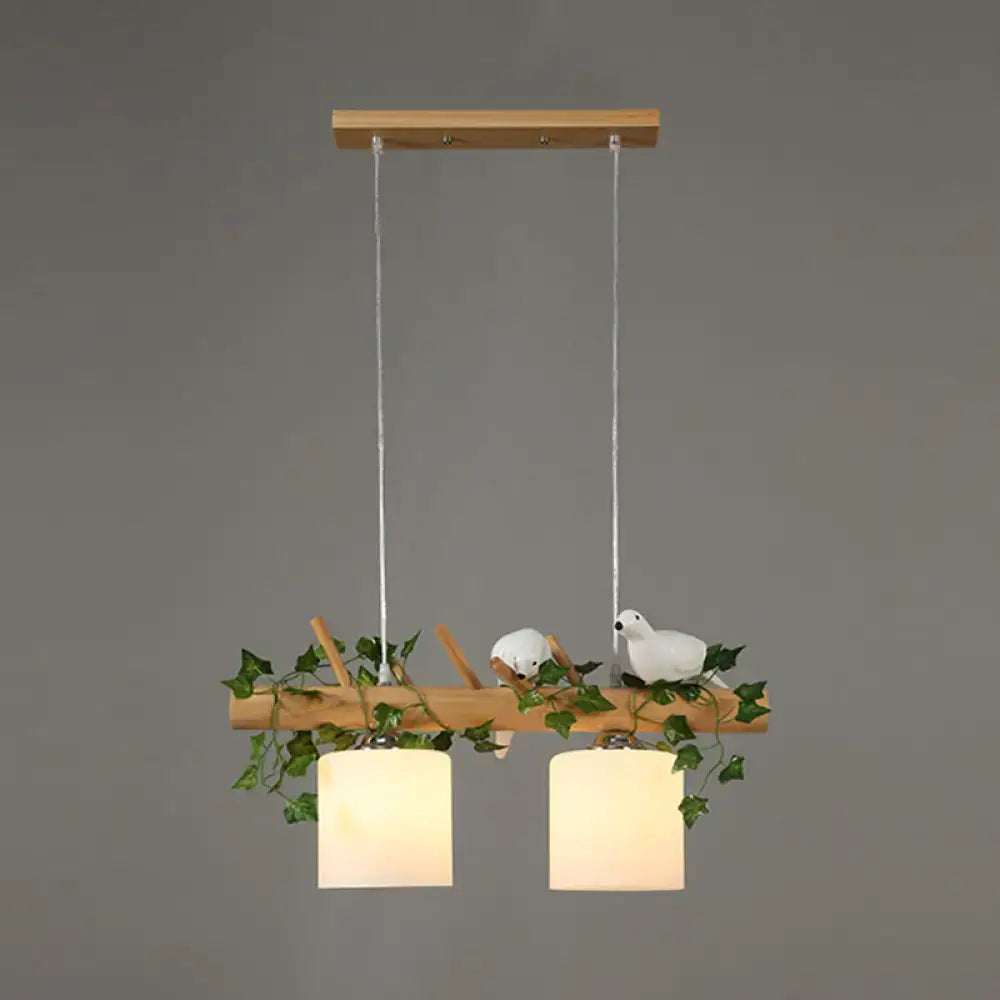 Decorbites modern wood linear island lighting with warm cylindrical shades and maple leaf plant accents on natural wood branch