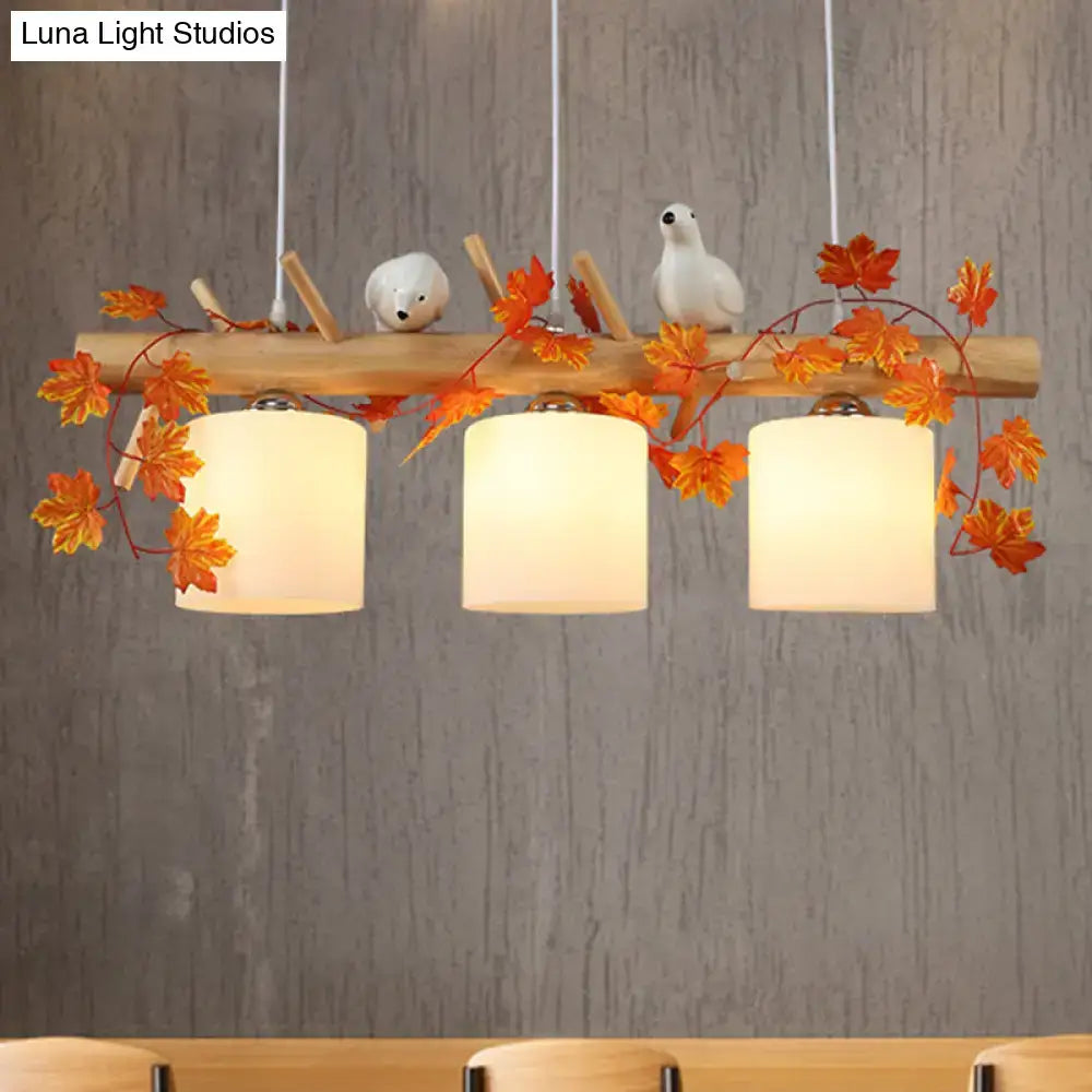 DecorBites™ modern wood linear island lighting with warm wood shades, white ceramic birds, and maple leaf plant accents