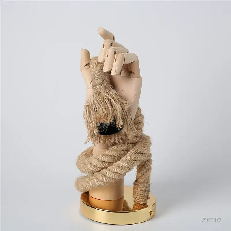 A beige wooden hand shape hemp rope wall light with natural grain and thick tan rope knot for restaurant corridor