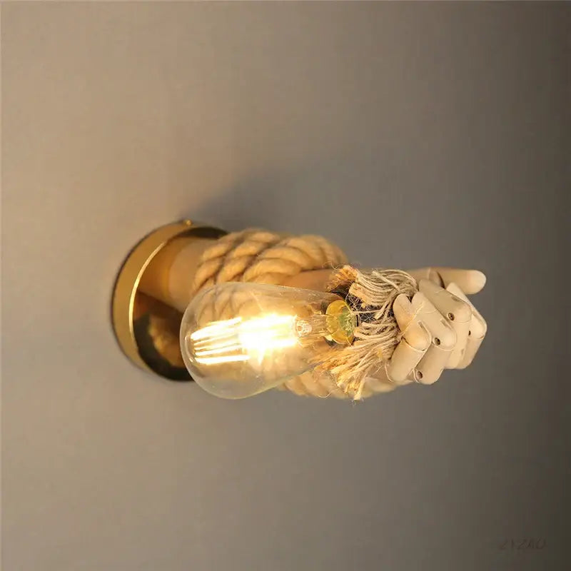 Rustic brass wall sconce with hand shape hemp rope gripping bulb ideal for restaurant corridor lighting