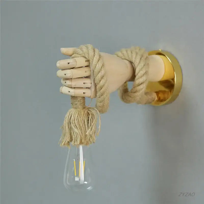 Rustic wooden hand shape hemp rope wall light featuring a beige rope and led bulb with tassel for restaurant corridor