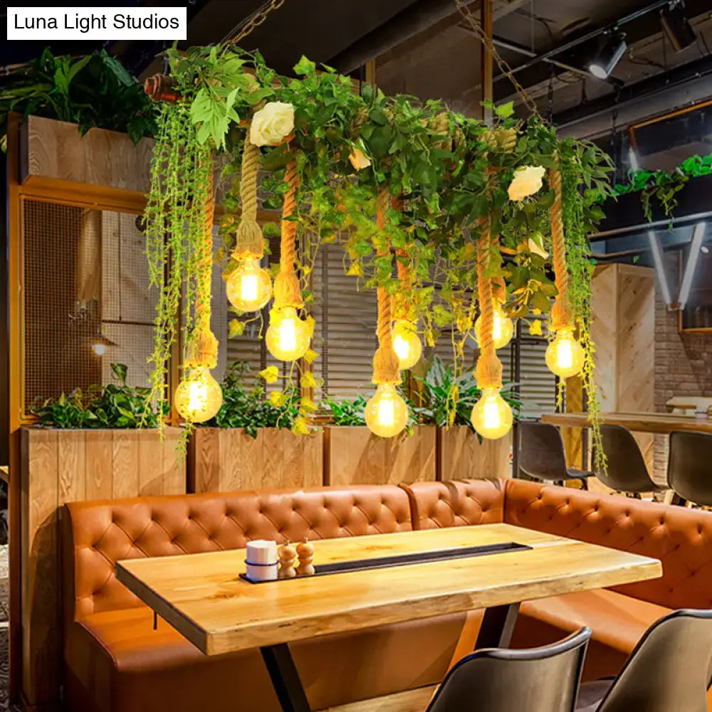 Rustic wooden island light fixture with warm edison bulbs hanging from twisted rope and decorative vines