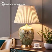 Sage green american style ceramic table lamp with gold leaf bamboo and bird decor topped by a pleated fabric shade