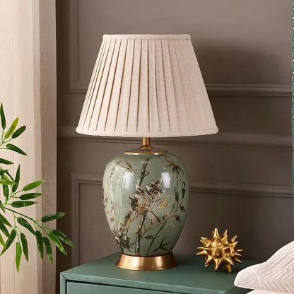 Sage green american style ceramic table lamp with gold bird and bamboo decor and off-white pleated fabric shade