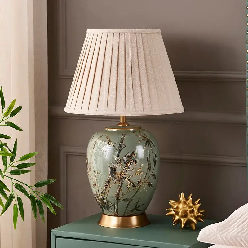 Sage green american style ceramic table lamp with gold bird and bamboo decor and off-white pleated fabric shade