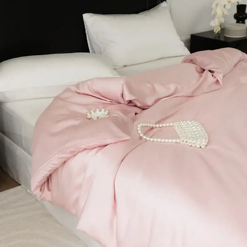 A delicate pearl-embellished clutch rests on a sage green double layer satin queen duvet set in bedroom bedding