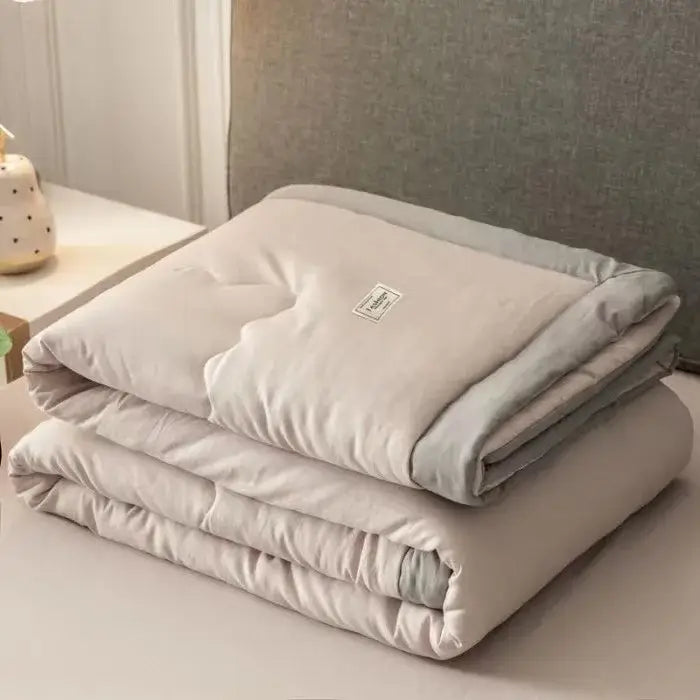 A soft beige decorbites cooling cotton quilt with subtle gray border and label for bedroom use