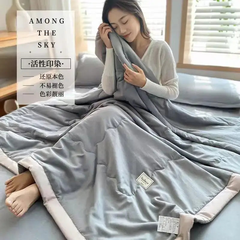 Soft gray quilted decorbites cooling cotton quilt with subtle sheen and light pink trim for bedroom use