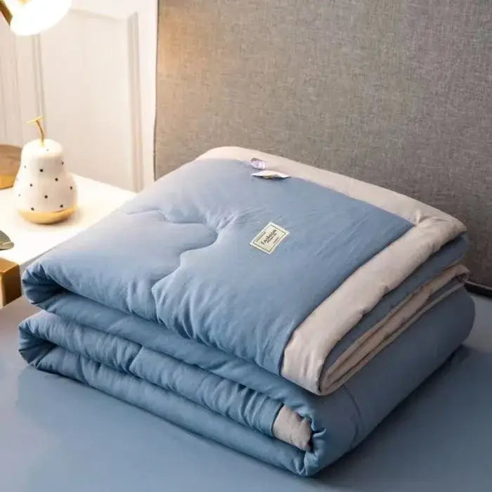 A soft light blue decorbites cooling cotton quilt with beige border and subtle stitching for bedroom decor