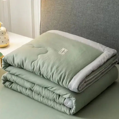 A soft sage green cooling cotton quilt with plush white lining and subtle stitching from decorbites cooling cotton collection