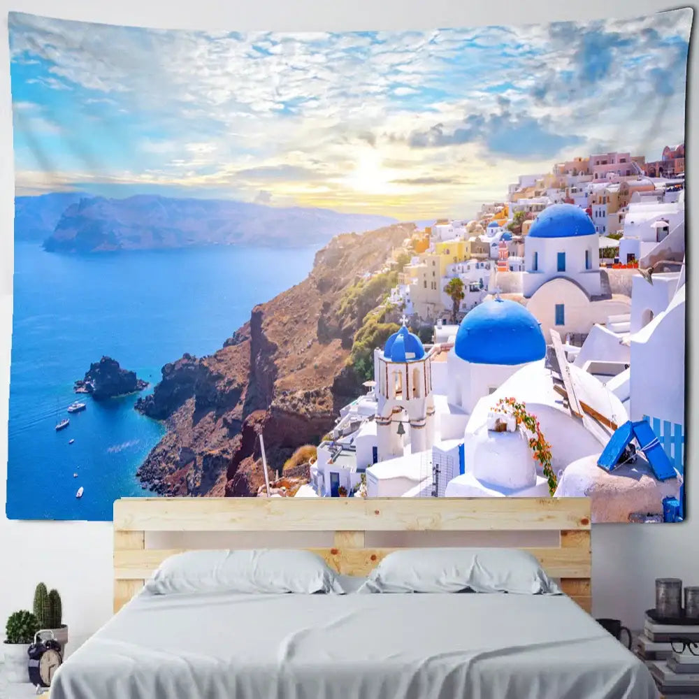 A vibrant blue and white Santorini castle village sunset tapestry hanging above a wooden bed frame