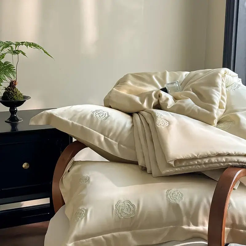 Cream-colored satin quilt set with delicate eucalyptus fiber flower embroidery for elegant bedroom decorbites use