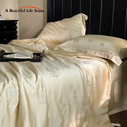 Cream-colored satin quilt set with delicate silver eucalyptus fiber flower embroidery for elegant bedroom decorbites