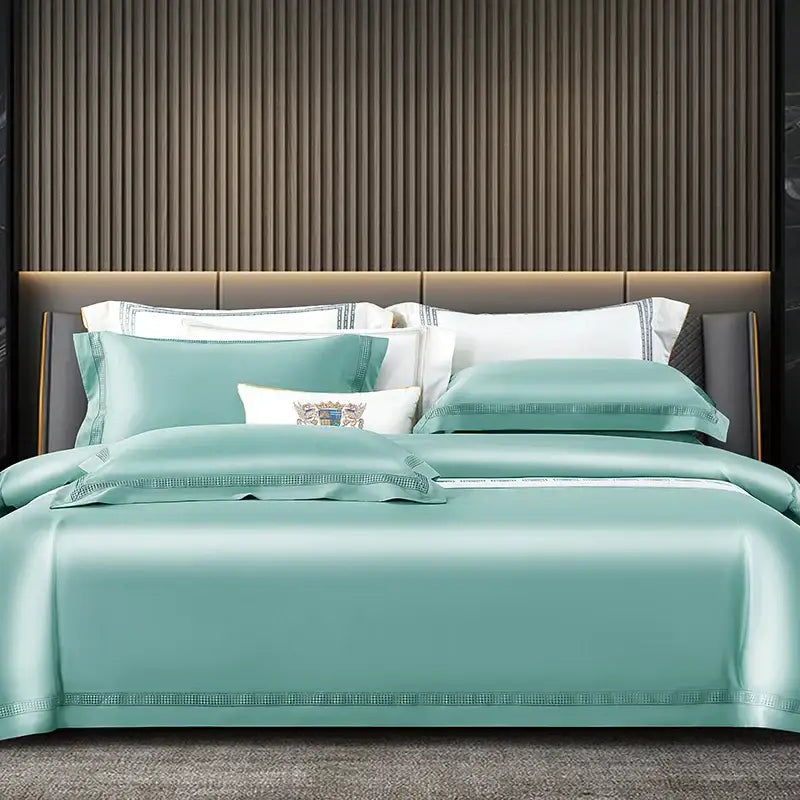 Teal satin duvet cover set with embroidered trim and decorative crest pillow in satin cream and gold egyptian cotton