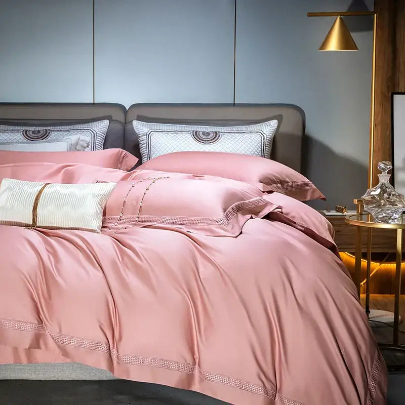 Pink satin duvet cover set with delicate beaded trim and coordinating pillows in cream and gold egyptian cotton