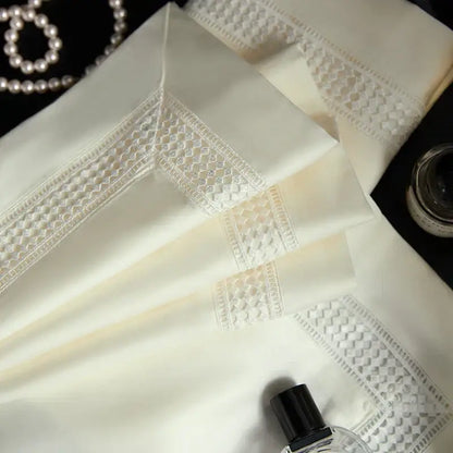 Cream-colored silk pillowcases with white lace trim complement the satin cream and gold egyptian cotton duvet cover set