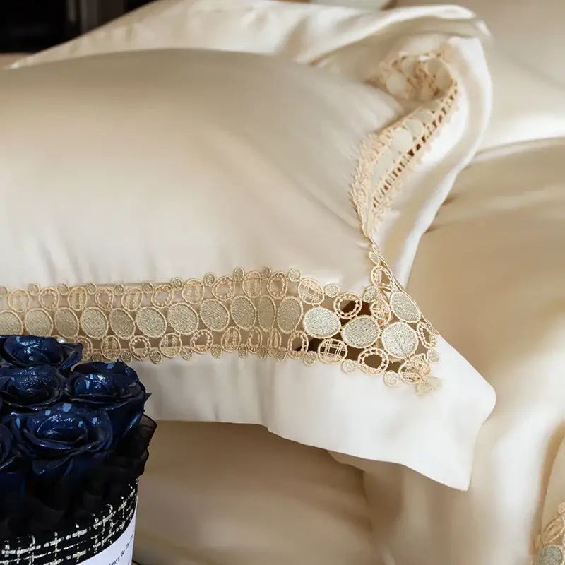 Cream satin pillow with gold lace trim featuring circular patterns in satin cream and gold lace eucalyptus duvet cover set