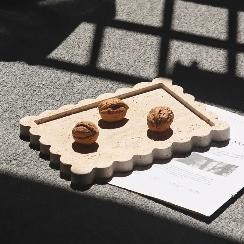 Beige scalloped calacatta viola marble tray with central recess holding three whole walnuts for kitchen luxury decor