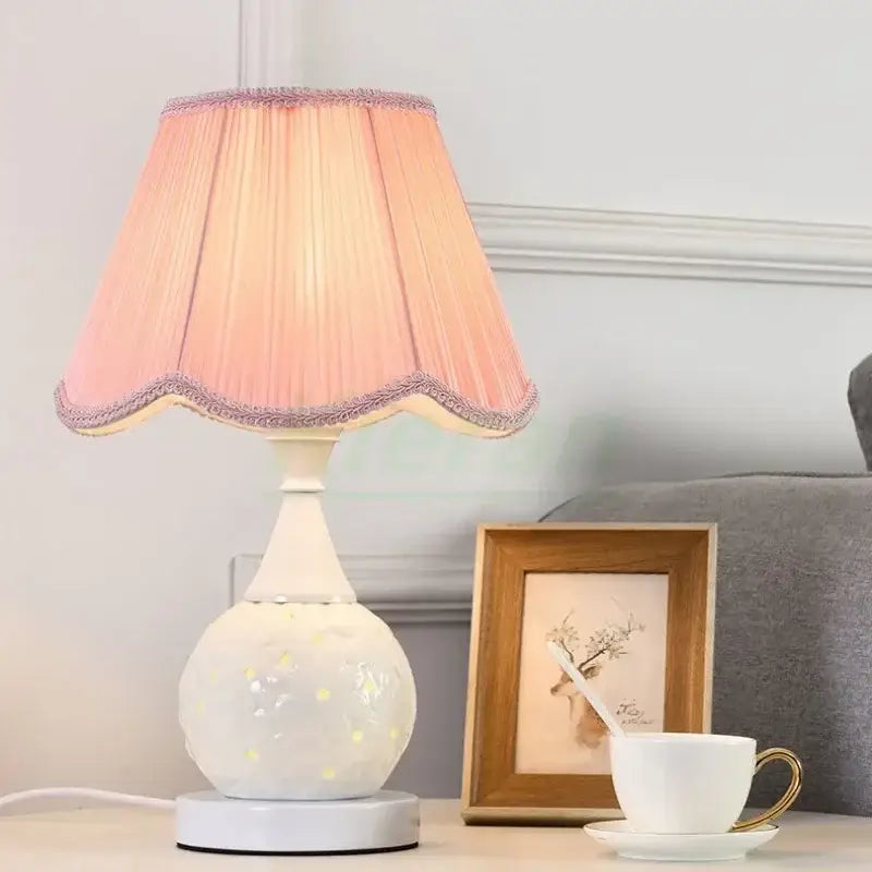A scalloped cream ceramic led desk lamp with a pink pleated shade and gold polka dots ideal for bedroom decorbites ceramic led